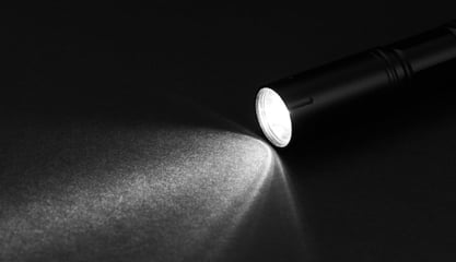 Der Lichtpegel einer Taschenlampe leuchtet vor einem schwarzen Hintergrund